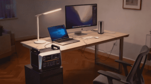 "Una estación de energía portátil Piforz alimentando una laptop en una oficina en casa o terraza, garantizando autonomía energética para el teletrabajo."