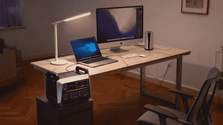 "Una estación de energía portátil Piforz alimentando una laptop en una oficina en casa o terraza, garantizando autonomía energética para el teletrabajo."