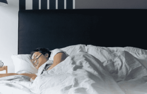 Paciente usando una máquina CPAP con respaldo de energía portátil durante la noche.