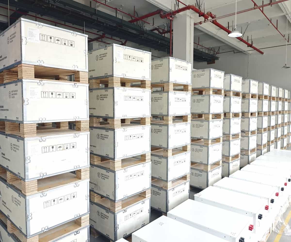 Sistemas de almacenamiento de energía y baterías de litio embalados de forma segura en cajas de madera en las instalaciones de Piforz para exportación B2B.