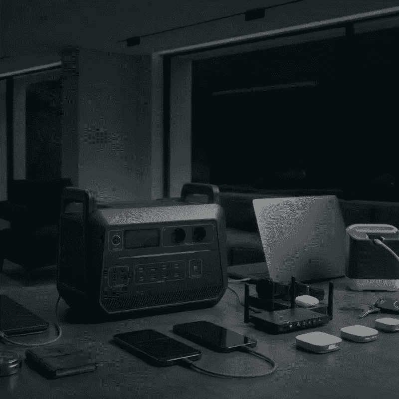 Estación de energía portátil alimentando un router y una computadora para mantener el internet durante un apagón.