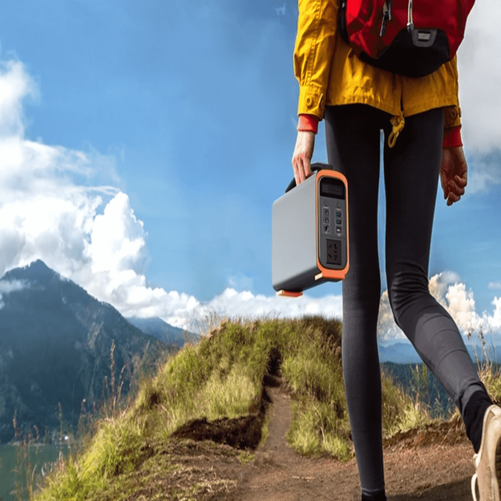 Persona haciendo senderismo y cargando una estación de energía portátil ligera para alimentar una máquina CPAP durante un viaje de camping off-grid.