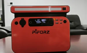 Estación de energía portátil marca Piforz de color naranja con pantalla LCD y puertos USB y CC para alimentación de respaldo.
