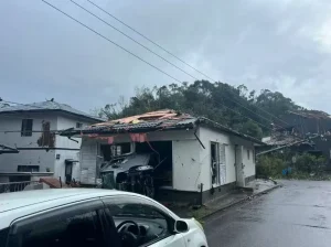 災害で被害を受けた家屋と車が放置されている様子。防災時の電源確保の重要性を示す。