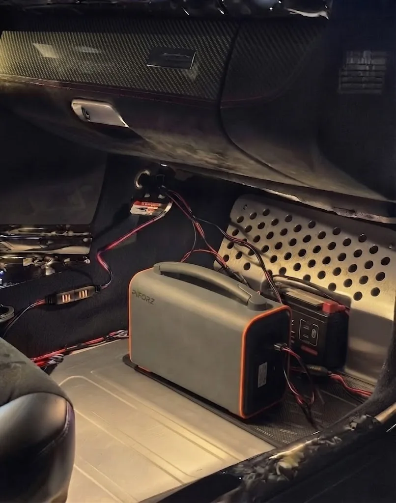車の足元や内部に設置された車載インバーターおよび走行充電用の配線接続状況。