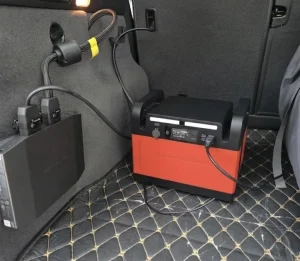 車の荷室に置かれ、専用ケーブルで車載充電されているポータブル電源。