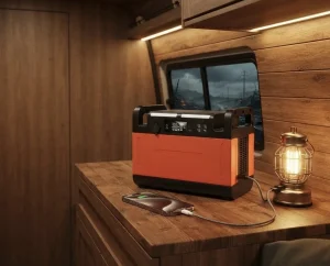 車中泊仕様のバンの中で、ランタンやスマートフォンに給電しているオレンジ色のポータブル電源。