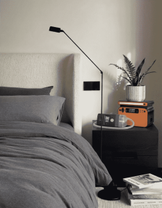 An orange Piforz portable power station on a modern black nightstand providing safe, silent backup power to a ResMed CPAP machine during a home blackout.