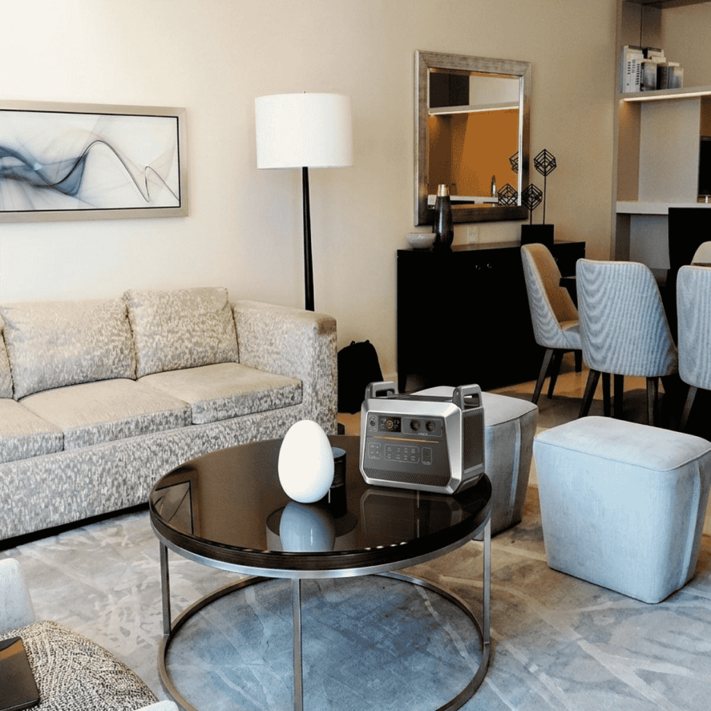 A modern high-capacity portable power station placed on a coffee table in a stylish living room for home emergency use