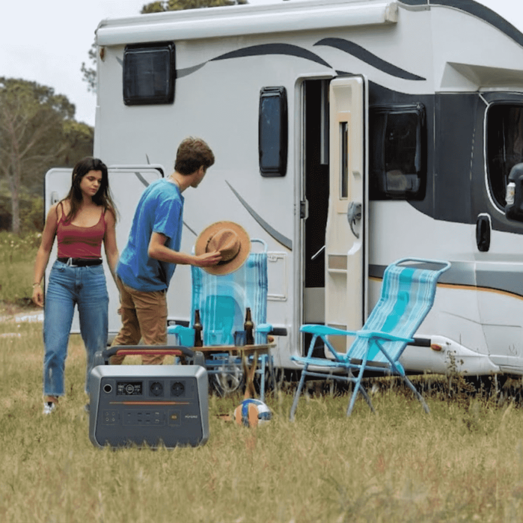A 2000 watt power station for rv being used to run a coffee maker and induction cooktop outside a camper van during a scenic road trip.