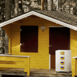 An all-in-one solar power system installed in a small wooden cabin, showing a compact design that integrates an inverter and battery backup.