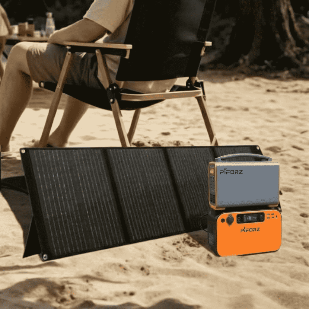 A high-capacity portable solar battery bank being used at a remote campsite to power laptops and lights via foldable solar panels