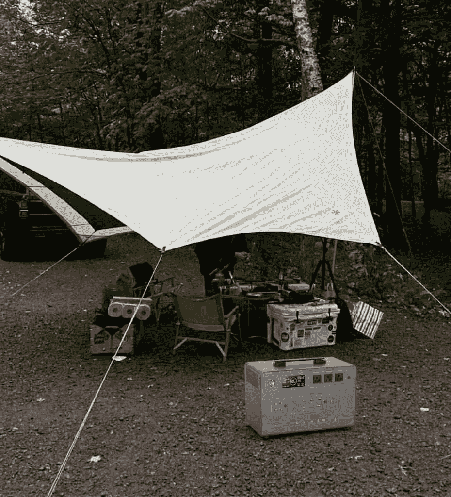 A high-performance portable solar power station 2000w connected to foldable solar panels, powering an RV's kitchen appliances and outdoor setup.