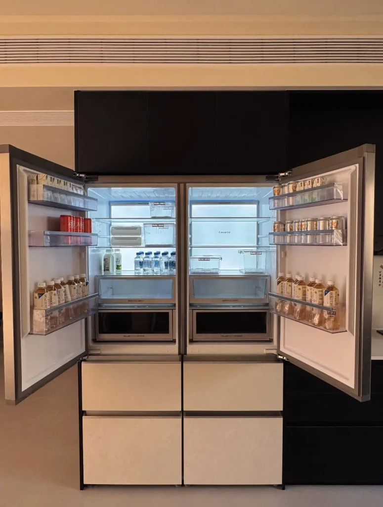 Interior view of a large double-door refrigerator fully stocked with food and drinks.